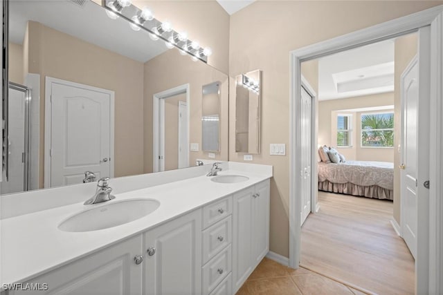 full bath with connected bathroom, double vanity, tile patterned flooring, and a sink