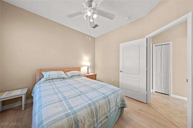 bedroom featuring light wood-type flooring, baseboards, ceiling fan, and visible vents