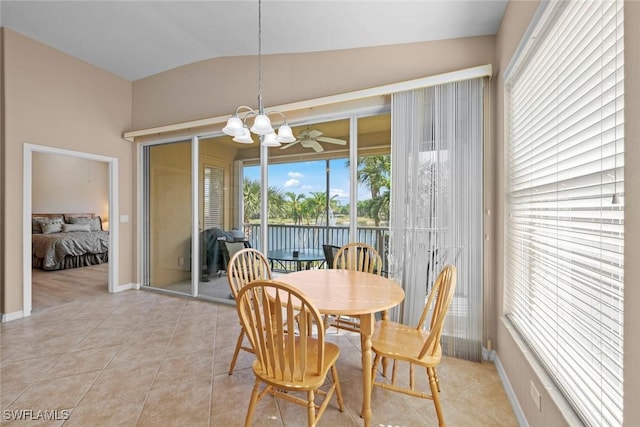 dining area featuring baseboards, vaulted ceiling, an inviting chandelier, and light tile patterned floors