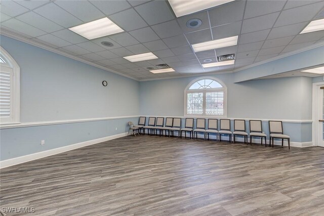 unfurnished room with baseboards, wood finished floors, and ornamental molding