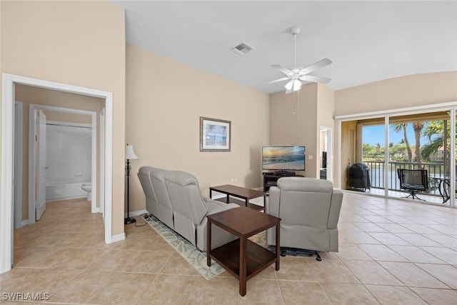 living area featuring light tile patterned floors, visible vents, baseboards, and ceiling fan