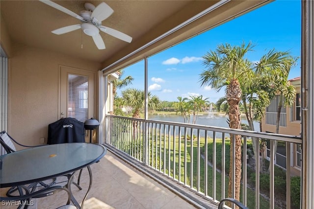 sunroom with a water view and a ceiling fan