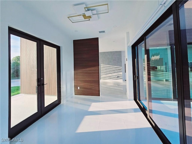 hallway featuring french doors, visible vents, and tile patterned flooring