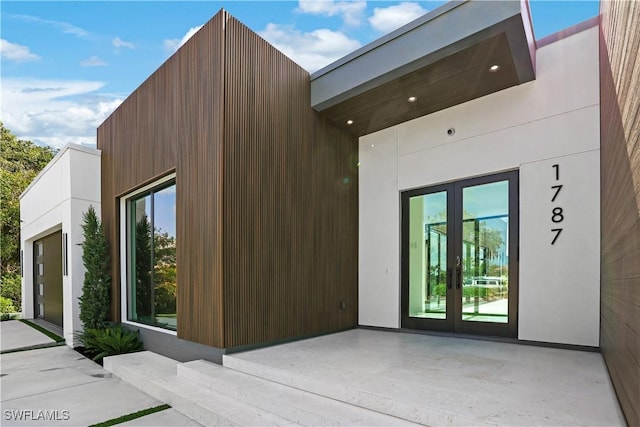 view of property exterior with stucco siding, a patio area, and french doors