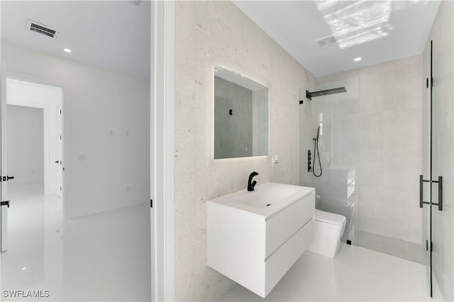 bathroom with a shower stall, toilet, vanity, and visible vents
