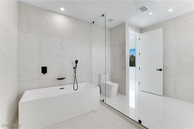 bathroom featuring a freestanding bath, toilet, visible vents, and recessed lighting