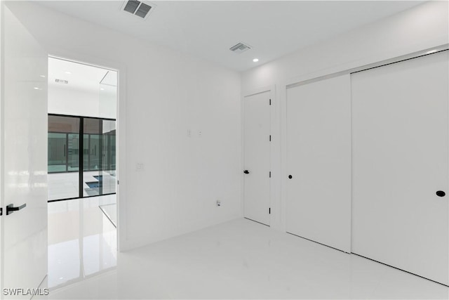 unfurnished bedroom with attic access, visible vents, recessed lighting, and a closet