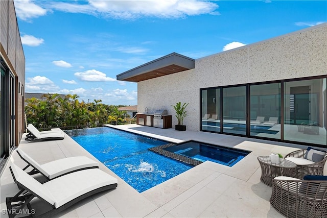 view of pool featuring grilling area, a pool with connected hot tub, and a patio