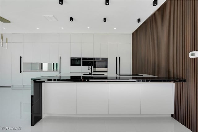 kitchen featuring dark countertops, white cabinetry, and modern cabinets