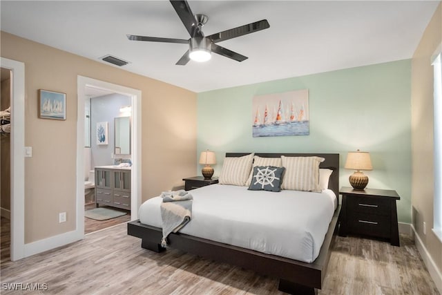 522 110th Ave N, Naples, FL 34108 - bedroom with wood finished floors, baseboards, ensuite bathroom, and ceiling fan
