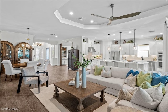 9476 Livorno Ct, Naples, FL 34119 - living room featuring arched walkways, ceiling fan, a chandelier, recessed lighting, and crown molding