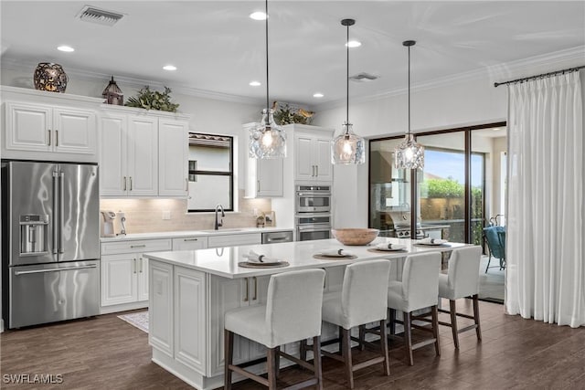 9476 Livorno Ct, Naples, FL 34119 - kitchen with appliances with stainless steel finishes, light countertops, a kitchen island, decorative backsplash, and a breakfast bar