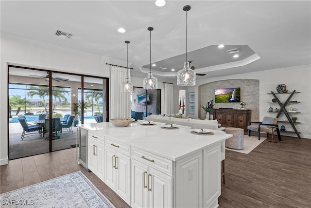 9476 Livorno Ct, Naples, FL 34119 - kitchen featuring a ceiling fan, crown molding, wine cooler, wood finished floors, and white cabinets