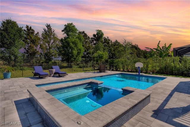 view of swimming pool with fence, a patio, and a pool with connected hot tub