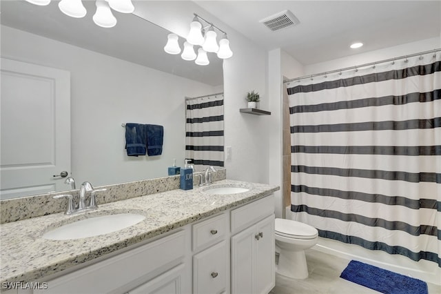 bathroom featuring visible vents, a sink, double vanity, and toilet