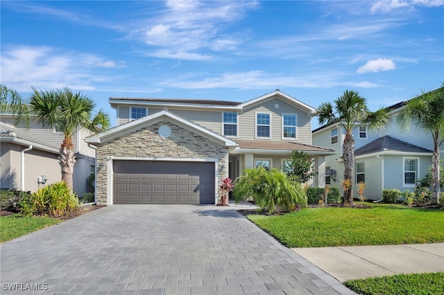traditional-style home featuring a garage, a front lawn, decorative driveway, and stone siding