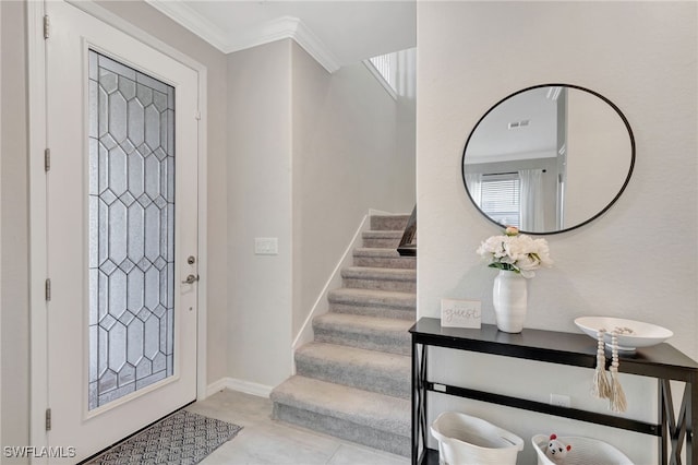 entryway with stairs, crown molding, visible vents, and baseboards