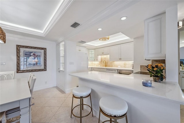 3443 Gulf Shore Blvd N Unit 403, Naples, FL 34103 - kitchen with a sink, freestanding refrigerator, decorative backsplash, a tray ceiling, and visible vents