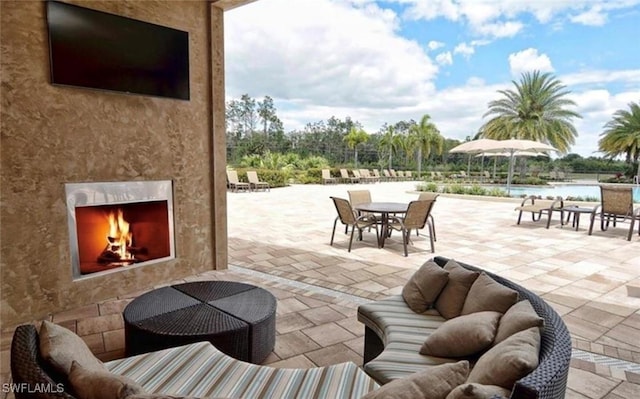 20374 Black Tree Ln, Estero, FL 33928 - view of patio / terrace featuring a warm lit fireplace