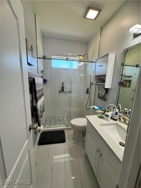 2618 35th Ave NE, Naples, FL 34120 - bathroom with a shower stall, toilet, marble finish floor, and vanity