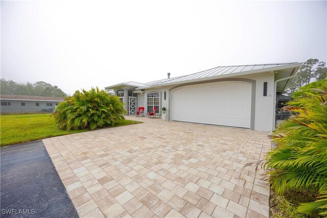 2618 35th Ave NE, Naples, FL 34120 - ranch-style home with stucco siding, decorative driveway, a standing seam roof, and a garage