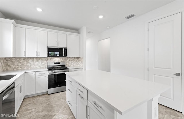 17313 Willow Tree Ln, North Fort Myers, FL 33917 - kitchen featuring stainless steel appliances, white cabinets, decorative backsplash, light countertops, and recessed lighting