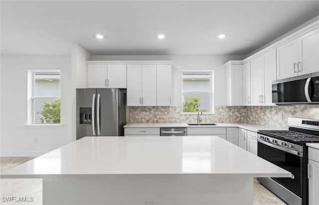 17313 Willow Tree Ln, North Fort Myers, FL 33917 - kitchen featuring appliances with stainless steel finishes, a sink, a kitchen island, white cabinetry, and recessed lighting
