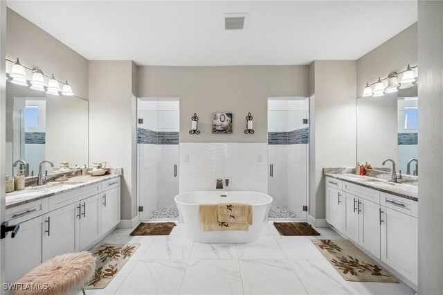 3407 20th St SW, Lehigh Acres, FL 33976 - full bathroom featuring a stall shower, two vanities, a sink, and visible vents