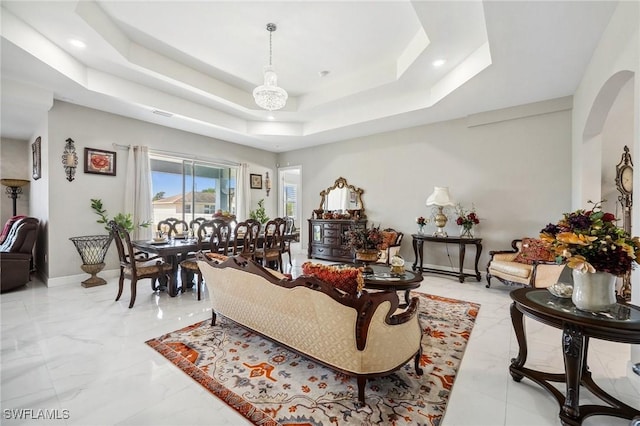 3407 20th St SW, Lehigh Acres, FL 33976 - living room featuring baseboards, recessed lighting, a raised ceiling, arched walkways, and marble finish floor