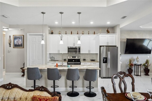 3407 20th St SW, Lehigh Acres, FL 33976 - kitchen with visible vents, a breakfast bar, appliances with stainless steel finishes, marble finish floor, and a sink