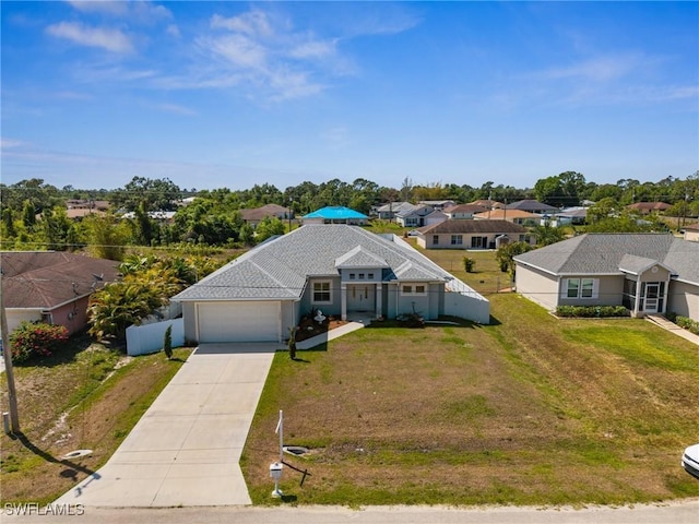 3407 20th St SW, Lehigh Acres, FL 33976 - view of front of house with a front yard, an attached garage, fence, concrete driveway, and a residential view