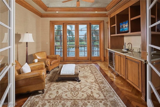 living area featuring wine cooler, ceiling fan, french doors, and crown molding