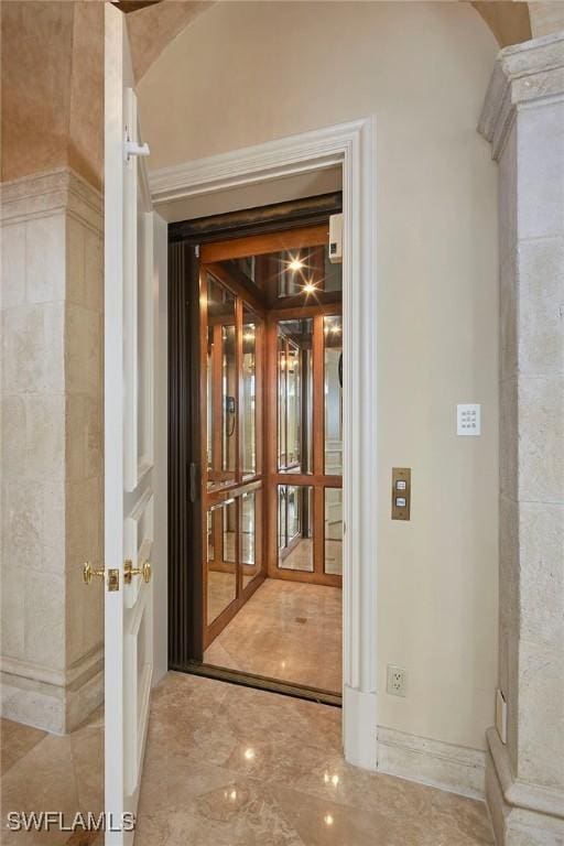 corridor featuring marble finish floor