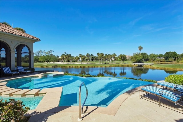 view of swimming pool with a pool with connected hot tub, a water view, and a patio