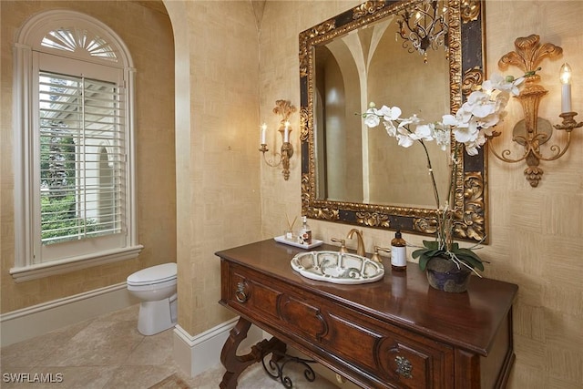 bathroom featuring toilet, vanity, tile patterned floors, and baseboards