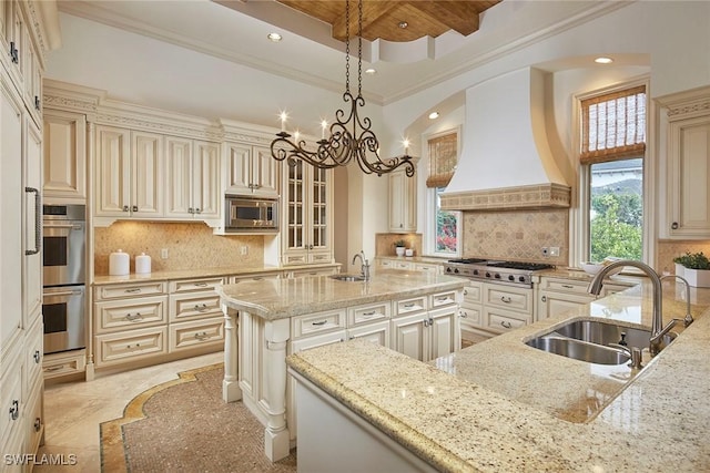 kitchen with premium range hood, cream cabinets, a sink, and stainless steel appliances