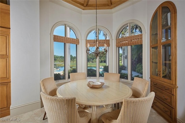 dining space with a high ceiling, a water view, ornamental molding, and a chandelier