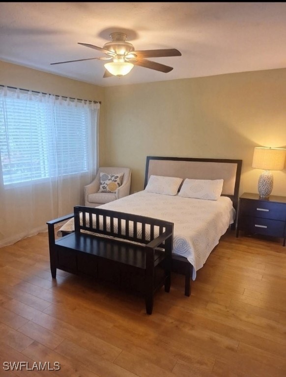 3130 Kings Lake Blvd Unit 7543, Naples, FL 34112 - bedroom featuring ceiling fan and wood finished floors