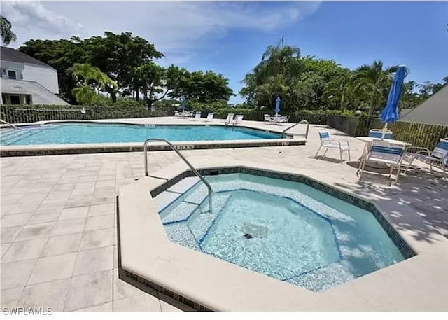 3130 Kings Lake Blvd Unit 7543, Naples, FL 34112 - pool featuring a patio area, a community hot tub, and fence