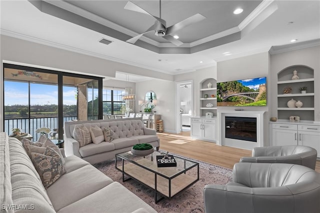 living area with ornamental molding, light wood-type flooring, a ceiling fan, a chandelier, and recessed lighting
