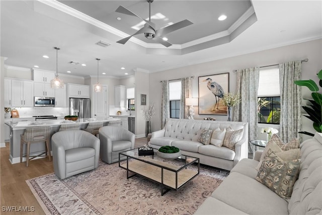 living area with healthy amount of natural light, light wood-style flooring, ornamental molding, ceiling fan, and recessed lighting