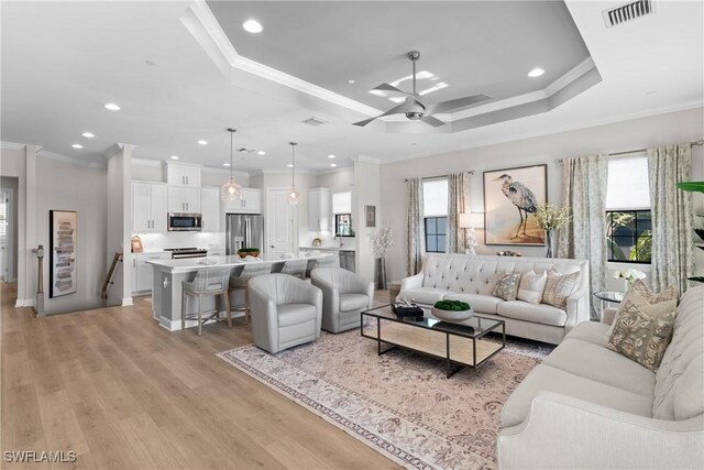 living room with plenty of natural light, crown molding, recessed lighting, a ceiling fan, and light wood-style flooring