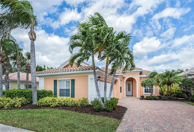 8511 Alessandria Ct, Naples, FL 34114 - mediterranean / spanish house featuring a tiled roof, decorative driveway, a garage, a front yard, and stucco siding