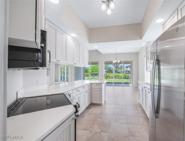 8511 Alessandria Ct, Naples, FL 34114 - kitchen featuring light countertops, an inviting chandelier, a peninsula, and freestanding refrigerator
