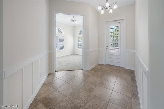 8511 Alessandria Ct, Naples, FL 34114 - doorway to outside with a decorative wall, light tile patterned flooring, ceiling fan with notable chandelier, and wainscoting