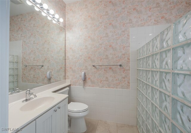 8511 Alessandria Ct, Naples, FL 34114 - bathroom featuring a wainscoted wall, wallpapered walls, toilet, tile patterned floors, and vanity