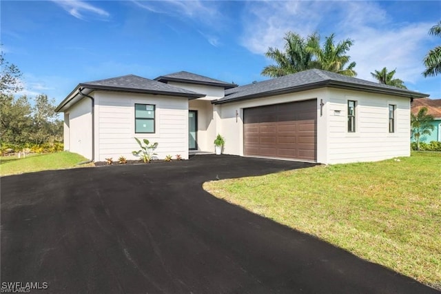 view of front of property featuring driveway, a front lawn, and an attached garage