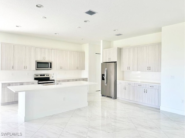 5048 Gambero Way, Ave Maria, FL 34142 - kitchen featuring an island with sink, visible vents, light countertops, and appliances with stainless steel finishes