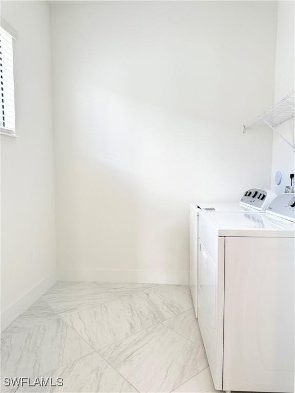 5048 Gambero Way, Ave Maria, FL 34142 - clothes washing area with baseboards, washer and dryer, laundry area, and marble finish floor