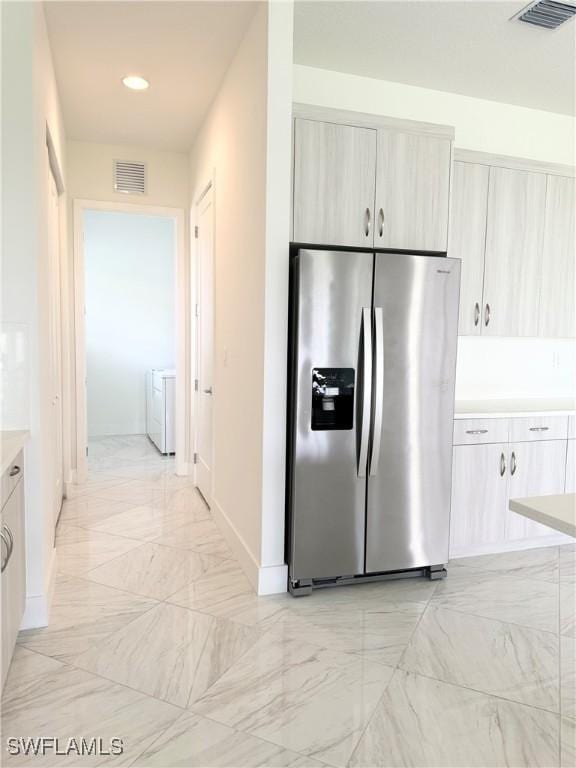 5048 Gambero Way, Ave Maria, FL 34142 - kitchen with visible vents, independent washer and dryer, stainless steel refrigerator with ice dispenser, and marble finish floor